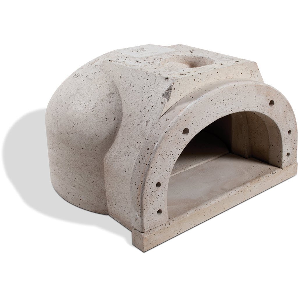 The image showcases a light gray, dome-shaped CBO 500 DIY Kit wood-fired pizza oven with a small arched opening at the front. The surface looks to be constructed from concrete or stone and casts a shadow to the left side on a white background. This elegant wood-burning oven perfectly illustrates the high-quality craftsmanship of Chicago Brick Oven, offering both flexibility and affordability with its 27" x 22" cooking surface.