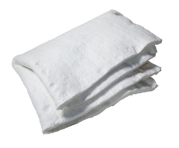 A stack of folded, fluffy white CBO-750 Insulating Blankets by Chicago Brick Oven is shown against a plain white background. The blankets appear soft and clean, forming a neat, orderly pile. Their Superwool® plush texture provides excellent thermal insulation, helping to reduce energy losses in your household.