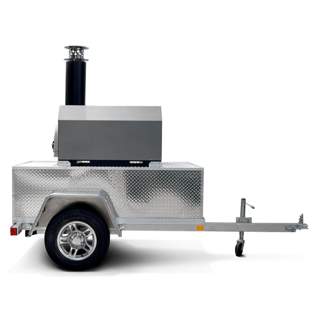 The CBO 750 Tailgater by Chicago Brick Oven is a compact, mobile wood-fired pizza oven mounted on a metal trailer with a single axle and a black chimney, designed for easy transportation. This high-performance outdoor pizza oven features a diamond plate pattern and comes equipped with a tow hitch and a small wheel to ensure stability when stationary. It offers a 38" X 28" cooking surface, capable of baking 2-3 ten-inch pizzas at once or producing 50-60 pizzas an hour.