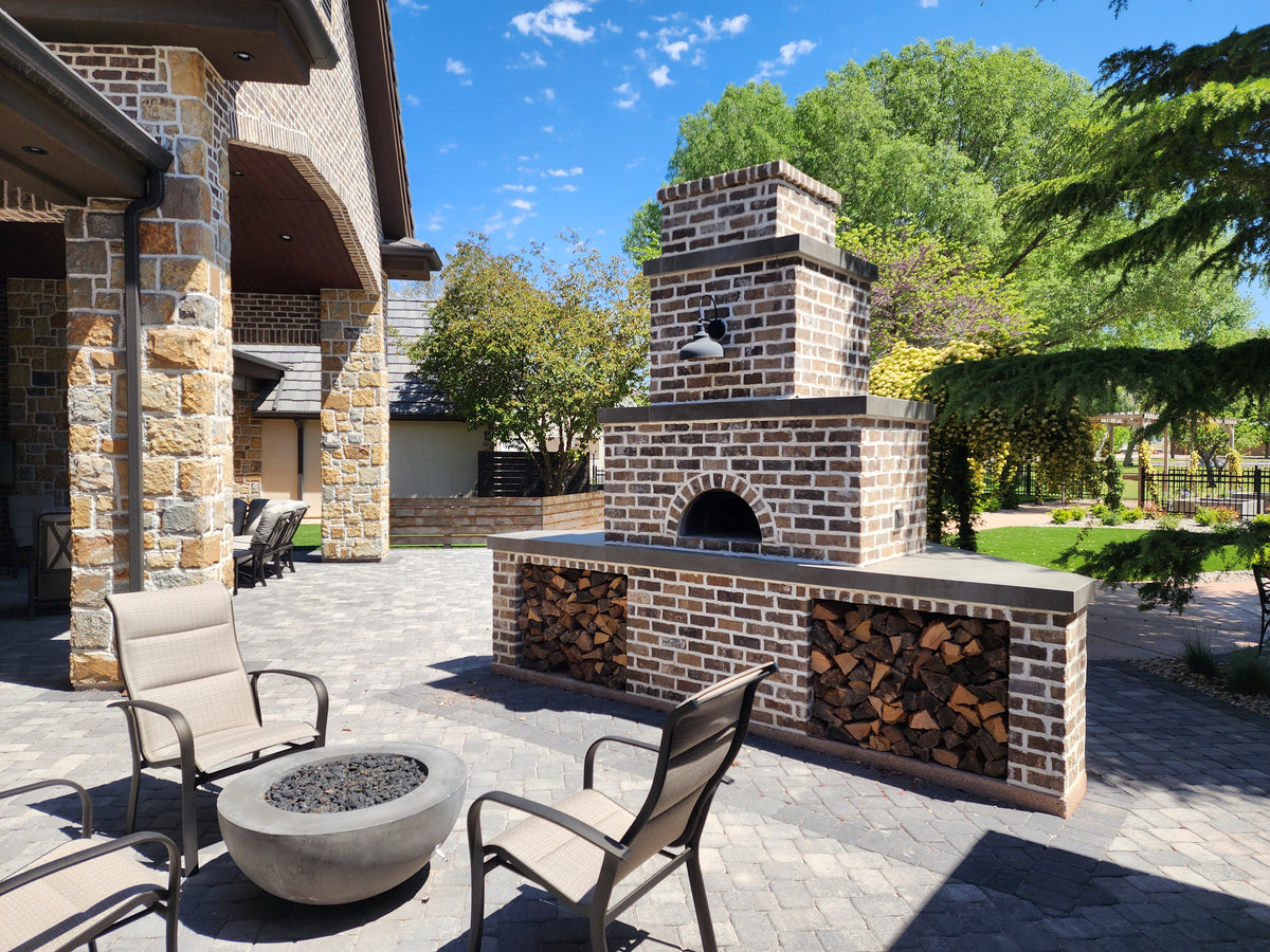 1000 DIY oven in a brick outdoor kitchen on a sunny patio with garden seating