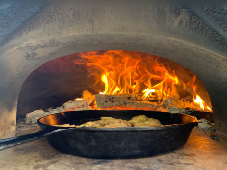 Cast-iron cooking beside the fire in a Chicago Brick Oven