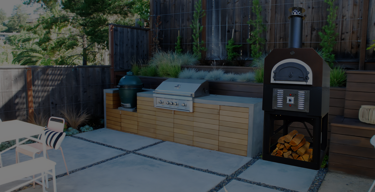 Copper Vein CBO 750 Hybrid Stand beside a timber-clad outdoor kitchen and landscaped patio