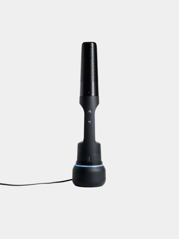 A sleek, black wireless microphone stands upright on a charging base with a power cord. The microphone features minimalist control buttons and boasts a modern design with a slightly textured grip reminiscent of the Arteflame Outdoor Grills' Looft Lighter X: Revolutionary Charcoal Grill Lighter and Easy Wood Fire Starting. The background is plain white.