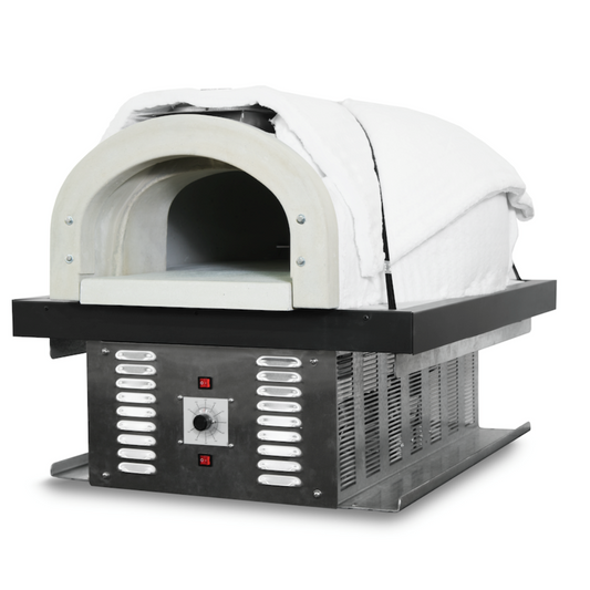 The CBO 750 Hybrid DIY Kit (Residential) by Chicago Brick Oven is a dual-fuel (gas and wood) pizza oven featuring a stainless steel design with a white, insulated dome cover. It includes a control panel with a dial and two digital indicators, ventilation slots on the front and sides, and stands on a solid metal base made of refractory cement, perfect for outdoor use.