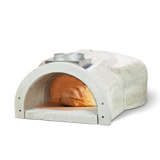 A high-performance CBO 1000 DIY Kit from Chicago Brick Oven with an arched opening showcases a loaf of bread inside. The rustic wood-burning oven exterior features a chimney on top. The golden-brown bread rests on the 53" x 39" baking surface, illuminated by the internal light, making it perfect for outdoor pizza oven aficionados.