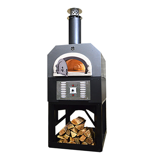 The CBO 750 Hybrid Stand (Commercial) pizza oven by Chicago Brick Oven, featuring a sleek black and silver finish, comes equipped with a chimney and a convenient open compartment at the base for storing chopped firewood. The oven door is ajar, showcasing the lit commercial-grade refractory cement interior. The front panel boasts control buttons and vents, making it an ideal choice for outdoor pizza oven enthusiasts who prefer versatility in fuel options with both gas and wood.