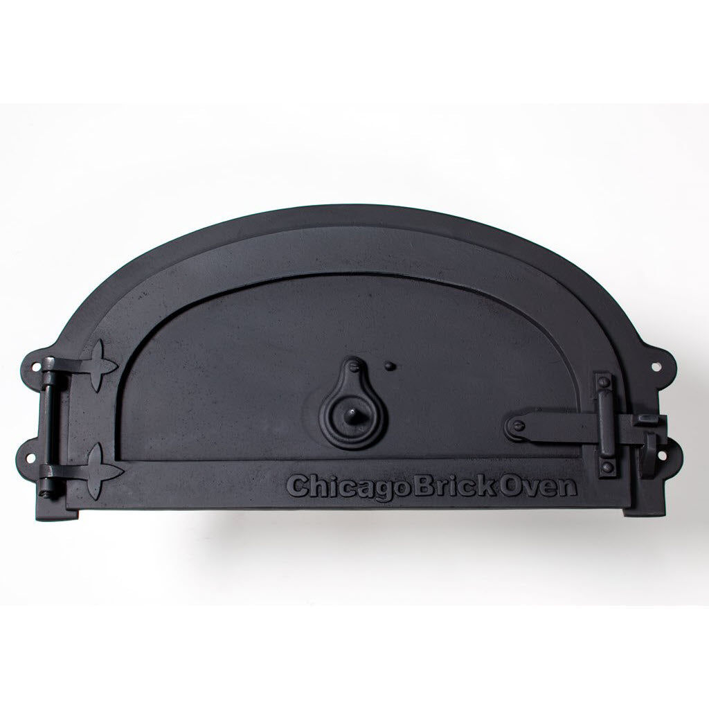 The CBO Decorative Door, crafted by Chicago Brick Oven for the CBO 500 & 750 Models, is a black, curved oven door featuring a small circular handle in the center and "Chicago Brick Oven" engraved at the bottom. Made from cast aluminum, it has hinges on the left side and a latch mechanism on the right. The door is displayed against a plain white background.