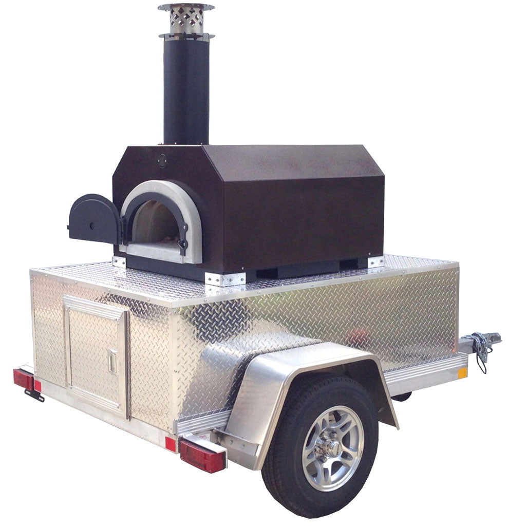 The CBO 750 Tailgater by Chicago Brick Oven is a mobile wood-fired pizza oven mounted on a small, metallic diamond-plate trailer. This model features a black body with an arched opening, topped with a cylindrical chimney. The trailer includes storage compartments and rides on a single axle with metal wheels on each side. With its 38" X 28" cooking surface, it can bake 2-3 pizzas of up to 10 inches at once, producing 50-60 pizzas an hour.