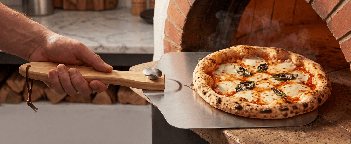 Folding pizza peel transferring a pizza at the oven